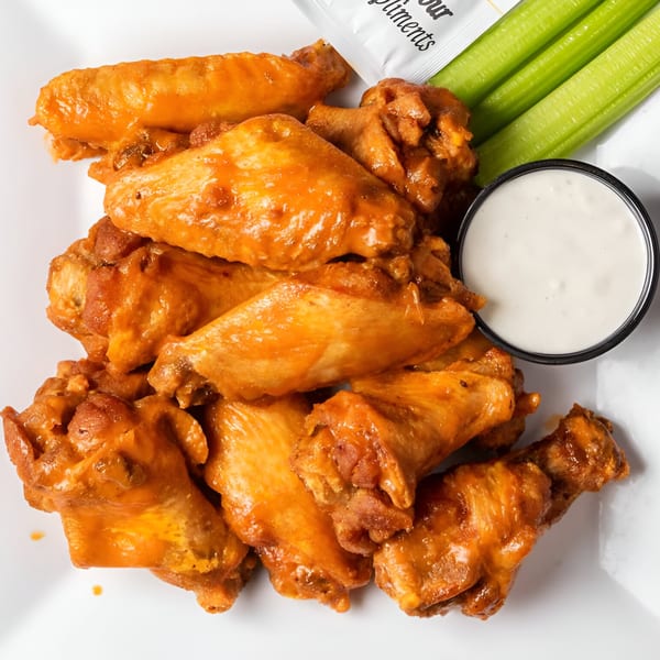 RJ Gator's buffalo wings with celery sticks and a side of ranch dressing.